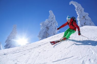 yokuş aşağı güneşli gün boyunca yüksek dağlarda kayak kayakçı
