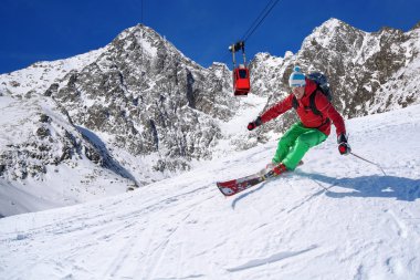 yokuş aşağı güneşli gün boyunca yüksek dağlarda kayak kayakçı