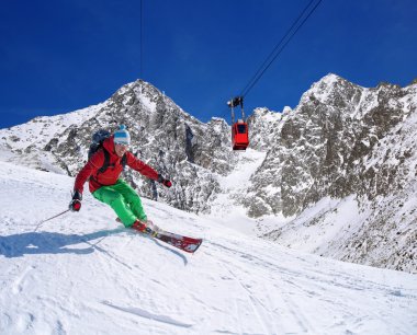 yokuş aşağı güneşli gün boyunca yüksek dağlarda kayak kayakçı