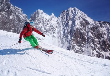 yokuş aşağı güneşli gün boyunca yüksek dağlarda kayak kayakçı