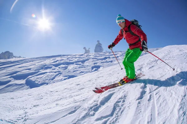 Skidåkare skidåkning slalom i höga berg under solig dag — Stockfoto