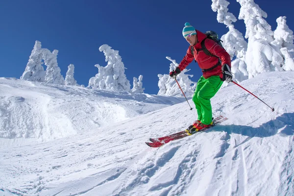 Esqui esqui downhill em altas montanhas durante o dia ensolarado — Fotografia de Stock