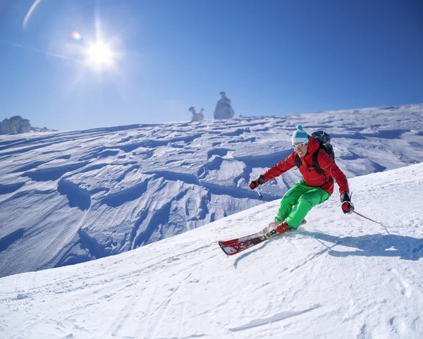 Skiër skiën afdaling in hoge bergen tijdens zonnige dag — Stockfoto