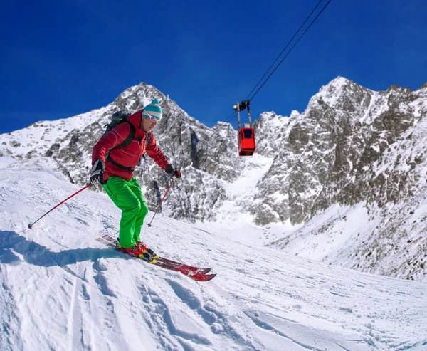 Skidåkare skidåkning slalom i höga berg under solig dag — Stockfoto