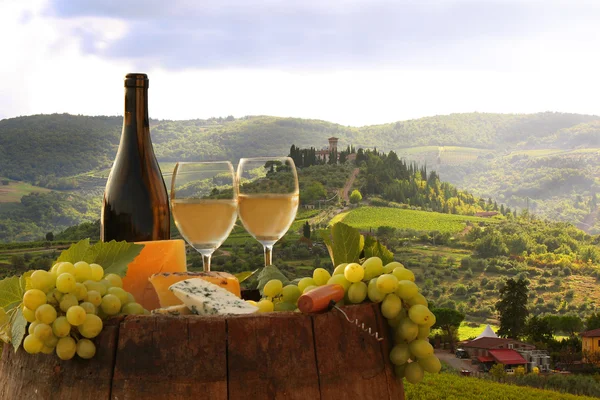 Fles van witte wijn met vat op wijngaard in chianti, Toscane, Italië — Stockfoto