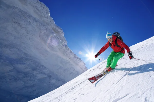 Σκιέρ σκι κατάβασης σε ψηλά βουνά κατά τη διάρκεια ηλιόλουστη ημέρα — Φωτογραφία Αρχείου