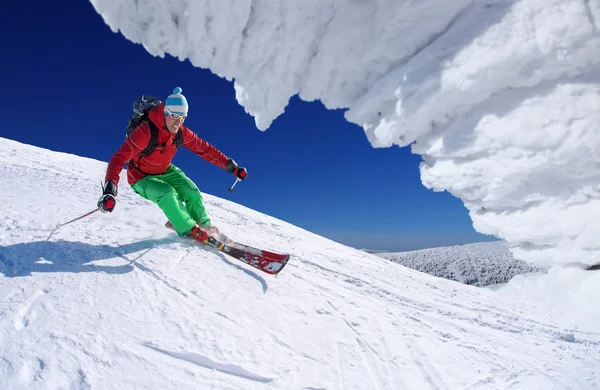 Skidåkare skidåkning slalom i höga berg under solig dag — Stockfoto