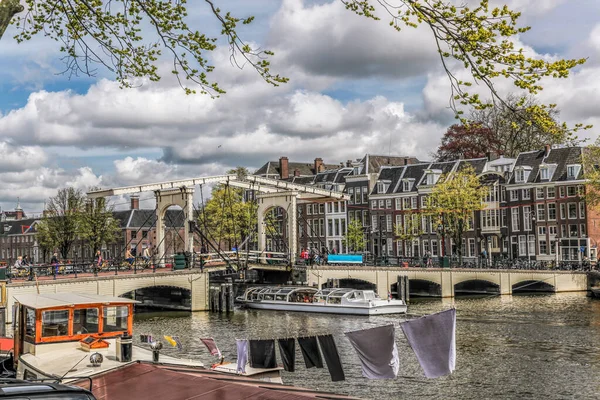 在荷兰的春天 阿姆斯特丹市的运河上有观光船 与老桥相望 — 图库照片
