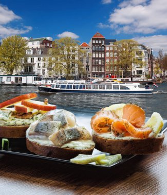 Hollanda kanalında turnuva teknesine karşı balık tabağı (salomon ve morina sandviçi) olan Amsterdam şehri