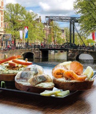 Hollanda kanalında turnuva teknesine karşı balık tabağı (salomon ve morina sandviçi) olan Amsterdam şehri
