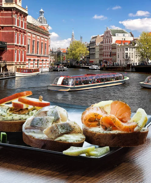 Hollanda kanalında turnuva teknesine karşı balık tabağı (salomon ve morina sandviçi) olan Amsterdam şehri
