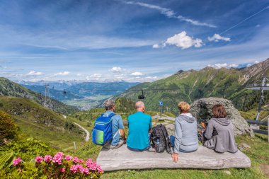 Avusturya 'nın Zell am See-Kaprun bölgesindeki Alpler ve teleferikler arasındaki gölü turistler izliyor