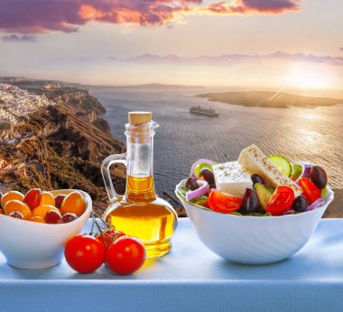 Greek salad against old town Thira on Santorini island in Greece