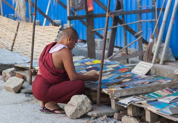 Buddhist monk choosing book on street market. Yangon. Myanmar. — Stock Photo, Image