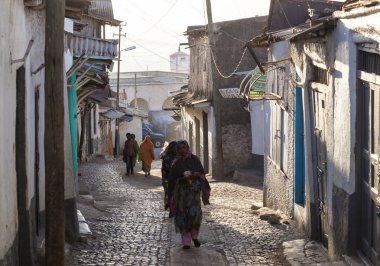 HARAR, ETHIOPIA - DECEMBER 23, 2013: Unidentified people of ancient walled city of Jugol in their  early morning routine activities that almost unchanged in more than four hundred years. clipart