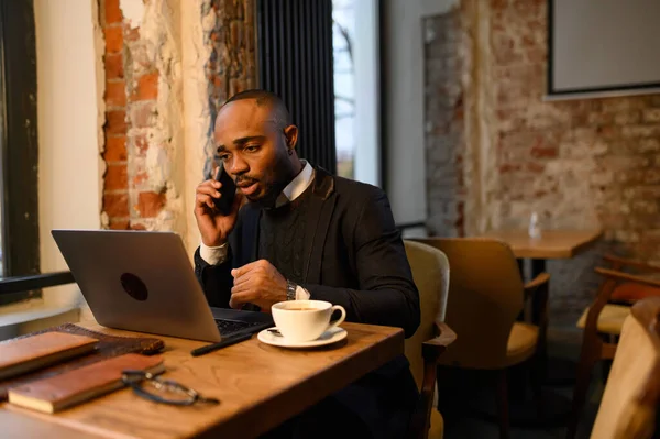 Um homem negro trabalha num computador portátil perto do seu rosto. videoconferências — Fotografia de Stock