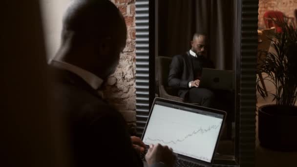 Zwarte zakenman met behulp van laptop voor het analyseren van gegevens aandelenmarkt, beurshandel online — Stockvideo
