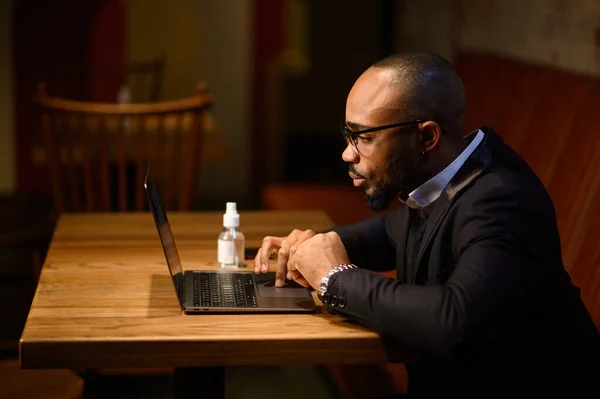 En afroamerikansk affärsman i kostym pratar på en videokonferens. Videokonferens med partner — Stockfoto