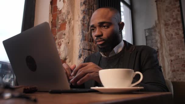 Takım elbiseli bir Afro-Amerikalı iş adamı bir video konferansında konuşuyor. Ortaklarla video konferansı — Stok video