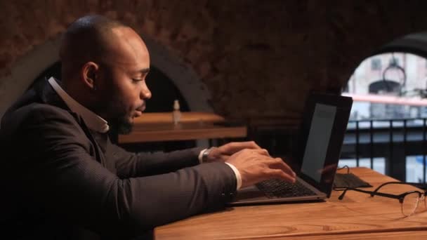 Молодий афроамериканський інвестор працює за комп'ютером, аналізуючи ринок цінних паперів. — стокове відео