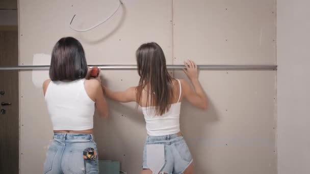 Renovace v bytě. dvě krásné ženy provést opravy v jejich domě — Stock video