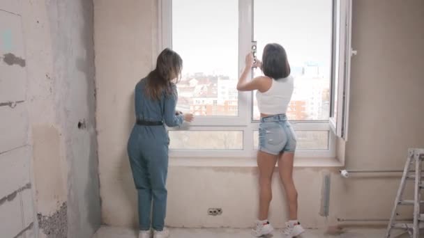 Mujeres jóvenes haciendo reparaciones de apartamentos juntas — Vídeo de stock