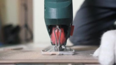 Tahtayı kesme işlemine başlamak için tahtayla elektrikli testereyi yakın çekim yap