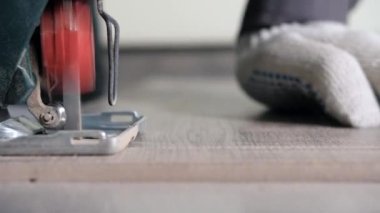 Tahtayı kesme işlemine başlamak için tahtayla elektrikli testereyi yakın çekim yap
