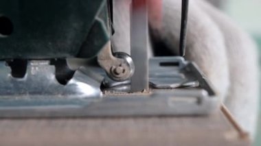 Tahtayı kesme işlemine başlamak için tahtayla elektrikli testereyi yakın çekim yap