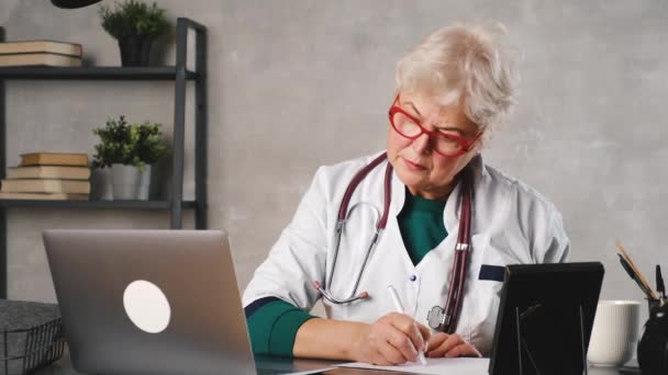 Dokter wanita di usia pertengahan. Telemedicine penggunaan komputer dan teknologi telekomunikasi untuk pertukaran informasi medis — Stok Video