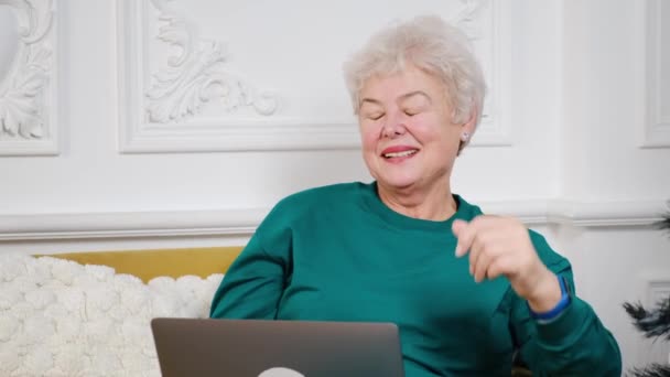 Ανώτερη ώριμη ηλικιωμένη γυναίκα βλέποντας την επαγγελματική κατάρτιση, σε απευθείας σύνδεση webinar στον υπολογιστή lap-top τηλεργασία ή κοινωνική εξ αποστάσεως μάθηση από το σπίτι — Αρχείο Βίντεο