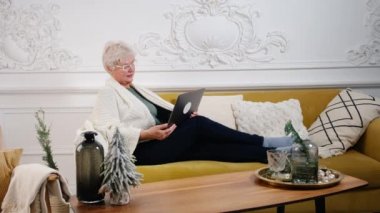 Yetişkin bir kadın iş eğitimini izliyor. Bilgisayarda uzaktan kumandayla ya da evden sosyal mesafeyi öğreniyor.