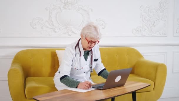Kobieta w średnim wieku rozmawia z pacjentem z wideokonferencją. Telemedycyna, konsultacje online z pacjentami — Wideo stockowe