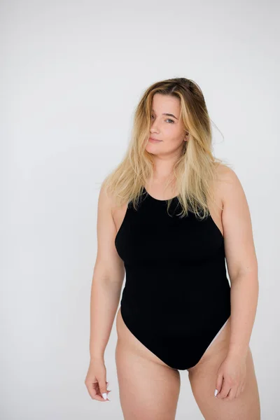Piękna otyła kobieta w czarnym stroju kąpielowym na szarym tle — Zdjęcie stockowe