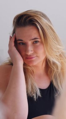 Dikey video. Kameraya poz veren mayolu, tombul, çekici bir kız. vücut pozitifliği ve insanlar