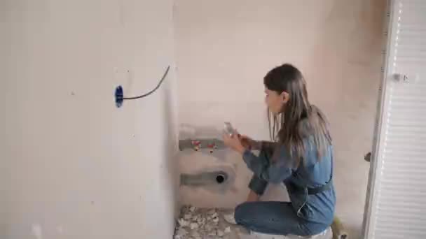 Una hermosa joven hace reparaciones en casa — Vídeo de stock