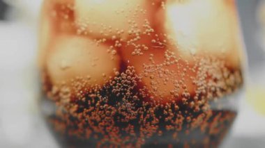 Karanlık bir arka planda buzlu soda dolu bir bardakta