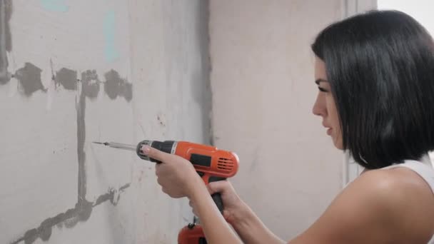 Menina bonita em macacão com broca elétrica — Vídeo de Stock