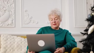 Mutlu yaşlı, yaşlı, kır saçlı kadın büyükanne web kameralı konferansa ailesini arıyor.