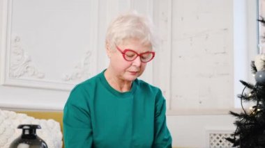 an adult woman with gray hair works at a laptop. video conference. Remote work