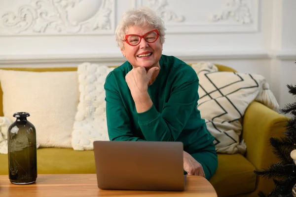 Щаслива стара старша сіроока бабуся на веб-камеру відеоконференція, що викликає сім'ю — стокове фото
