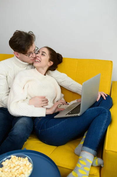 Um jovem casal bonito compras on-line. A rapariga compra um presente. A mulher está feliz com a compra — Fotografia de Stock