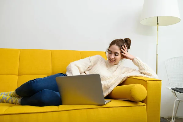 Μια νεαρή γυναίκα χρησιμοποιεί φορητό υπολογιστή για απομακρυσμένη εργασία ή σπουδές στο διαδίκτυο — Φωτογραφία Αρχείου