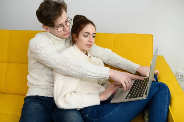 Retrato de una joven pareja sonriente usando un ordenador portátil en casa Fotos De Stock