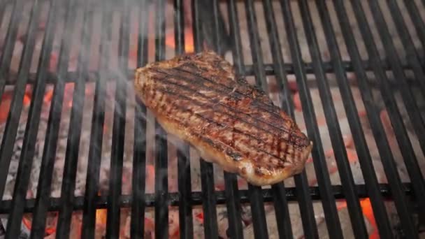 Pečení šťavnatý masový steak s kořením a bylinkami v hořících dřevěných uhlících oheň na grilu BBQ, plameny a kouř. Gril na grilu — Stock video