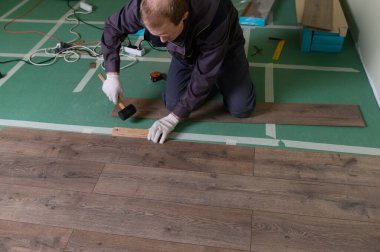 Efendi laminatı hazırlıyor. Adam zemini tamir ediyor.. 