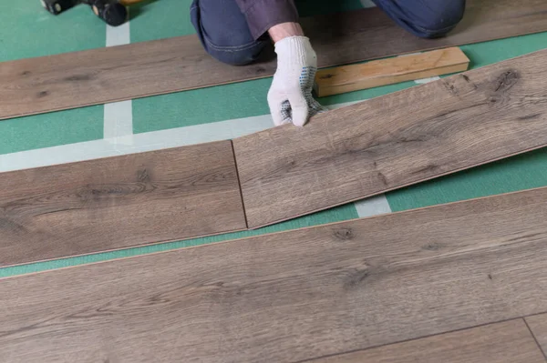 Efendi laminatı hazırlıyor. Adam zemini tamir ediyor.. 