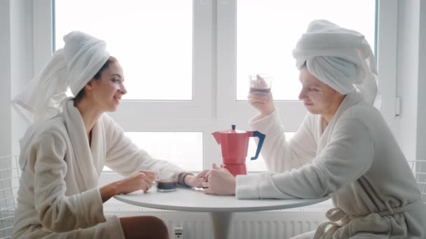 사랑하는 한 젊은 부부가 식탁에 앉아 서로 함께 보내는 시간을 즐기며 커피를 마시고 있다 — 비디오