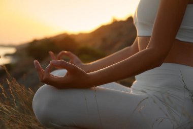 Gün batımında meditasyon yapan kadın, yakın çekim görüntüsü.