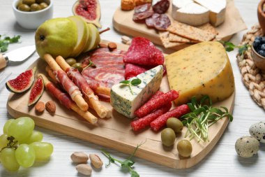 Beyaz ahşap masada servis edilen farklı lezzetli aperatifler.